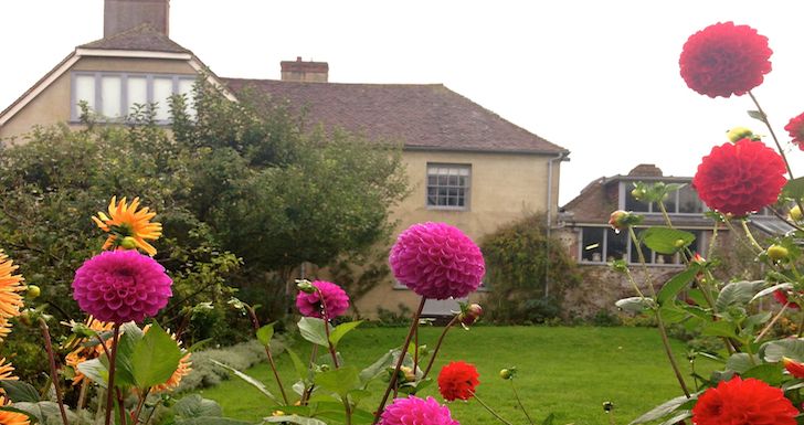 View of Charleston Farmhouse front the garden with dahlias in full bloom