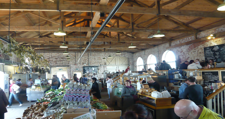 Stalls and shoppers inside The Goods Shed Canterbury
