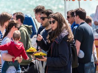 Visitors to Brighton Food Festival eating food as they walk along the seafront