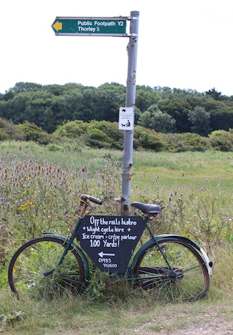 Vintage bicycle with sign pointing to Off The Rails railway cafe in Yarmouth