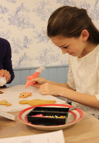 Girl taking a children's icing class Biscuiteers
