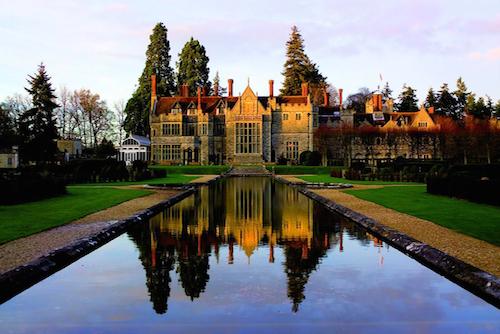 Rhinefield House with facade reflected in long ornamental pond in front of hotel