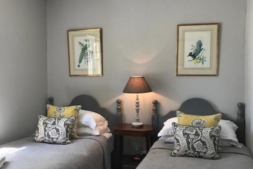 Twin bedroom with grey and yellow furnishings