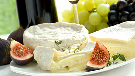 platter of camembert cheese with figs and grapes