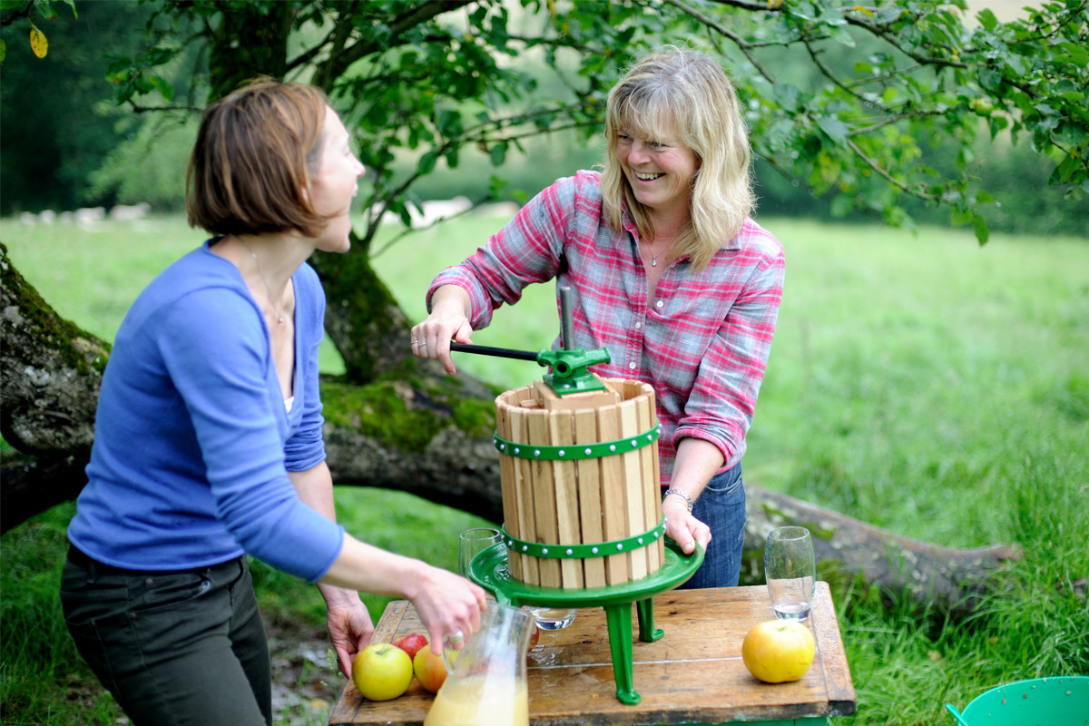 Two women making cider in Devon orchard